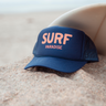 Blue trucker hat with 'SURF PARADISE' text on front