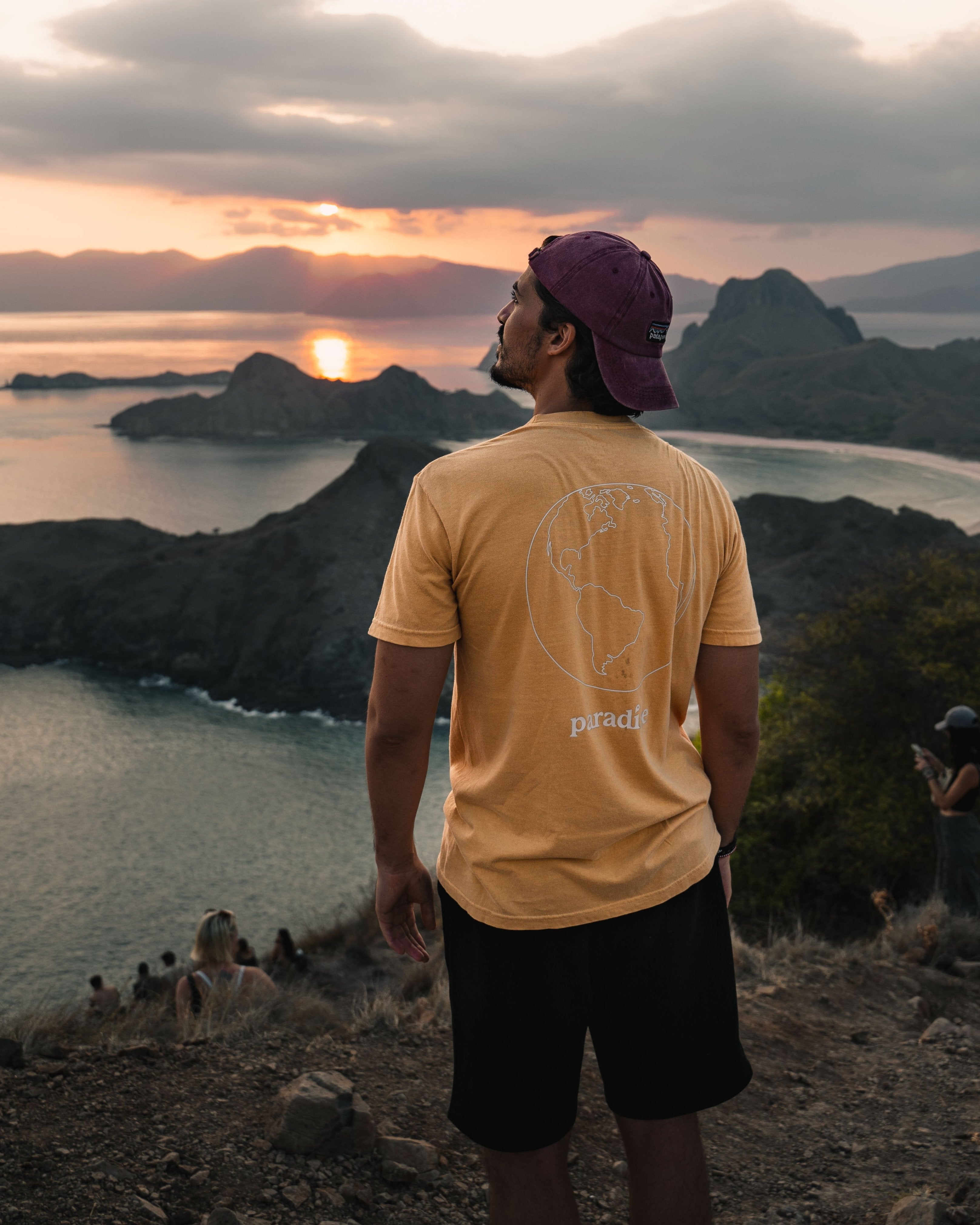 Man traveling wearing a t-shirt with a world graphic on the back 